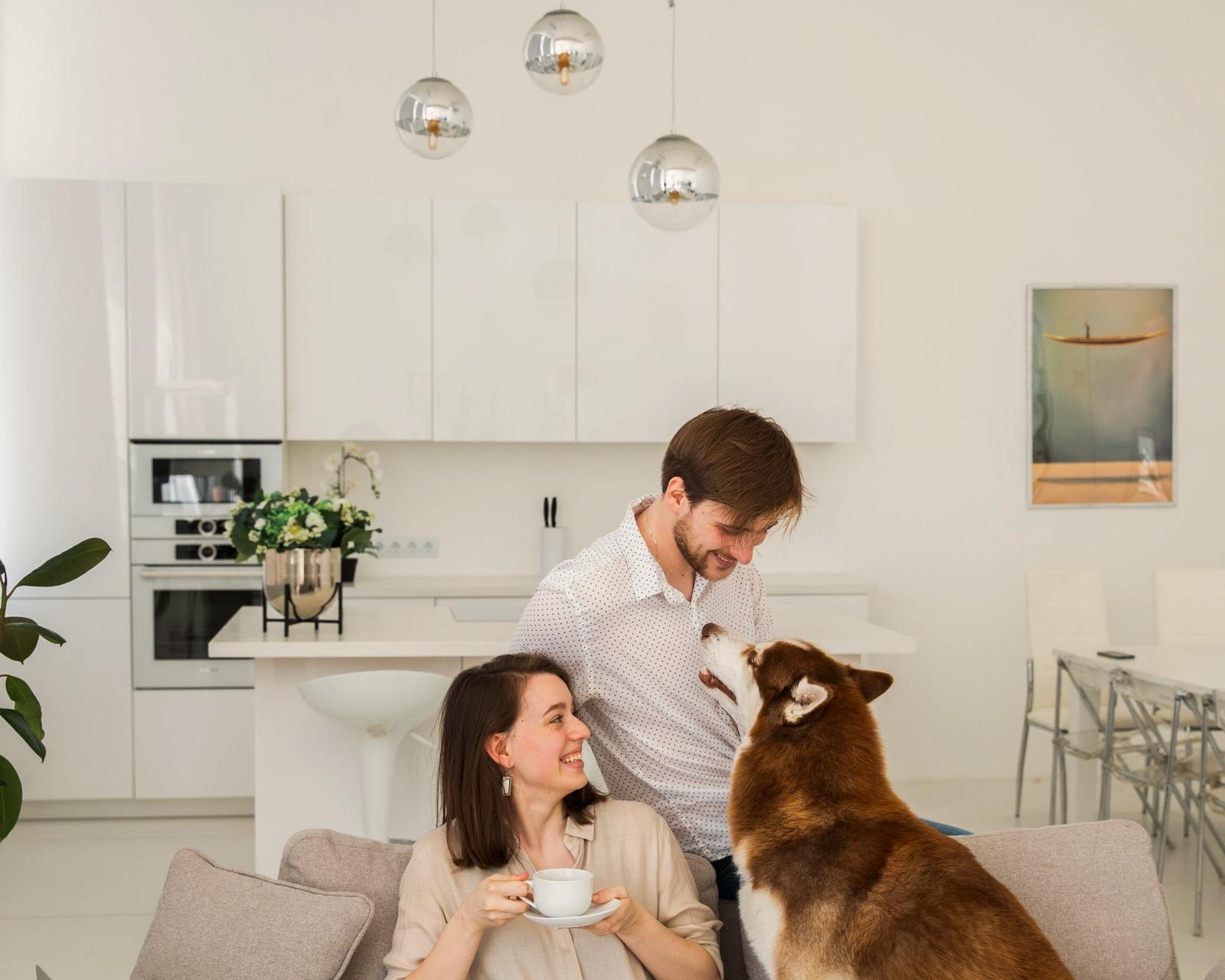 A couple relaxing with their dog in a bright living room
