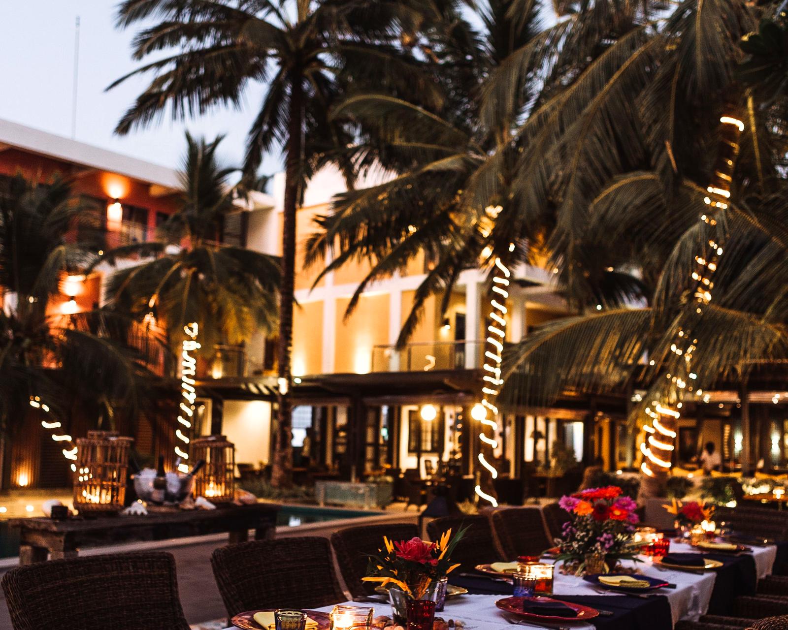 Restaurant patio dining at dusk under palm trees